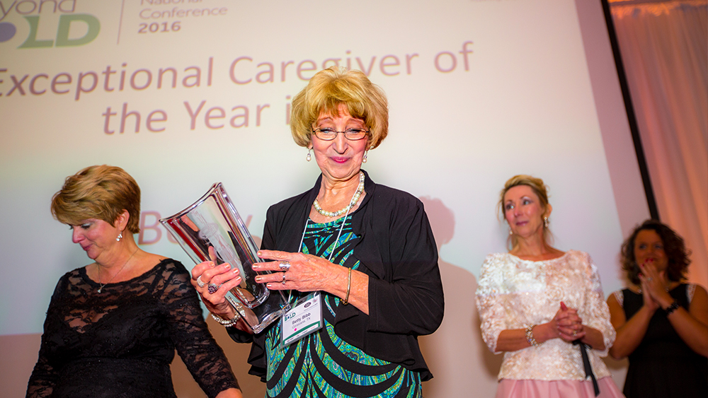 Betty holding a trophy at the Exceptional Caregiver of the Year 2016 Conference