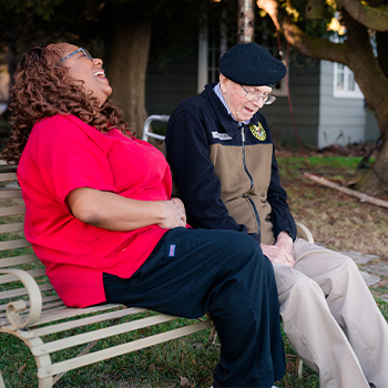 senior and caretaker sitting and talking together