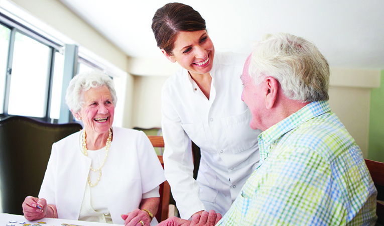 Caregiver speaking with elderly couple