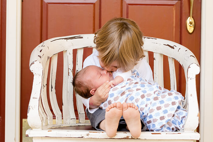 kid kissing younger sibling